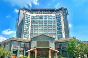A multi-story hotel with a prominent entrance and a large glass facade.