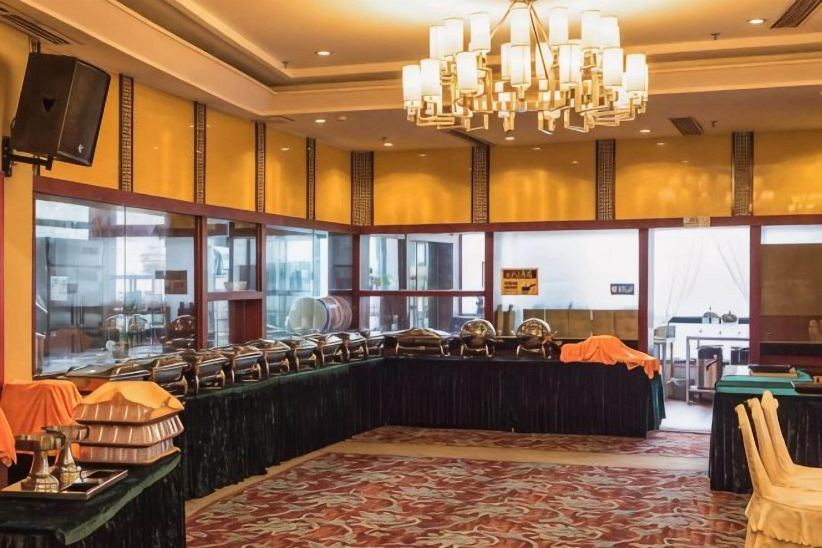 A banquet hall with a long table, chairs, and a chandelier.