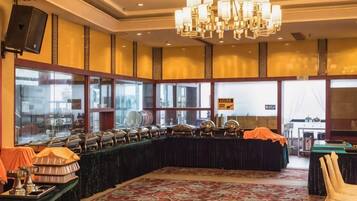 A banquet hall with a long table, chairs, and a chandelier.