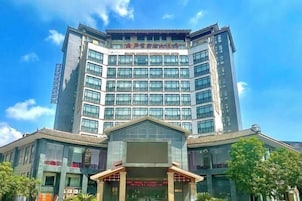 Un hotel de varios pisos con una entrada destacada y ventanas amplias.