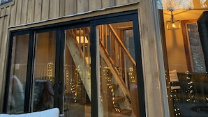 A wooden building with large windows and a visible staircase. - Eagle Ridge Treehouse (Stockbridge)