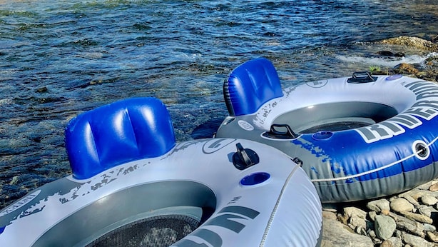 Two inflatable rafts on a rocky riverbank with a clear blue sky and mountains in the background. - Eagle Ridge Treehouse (Stockbridge)