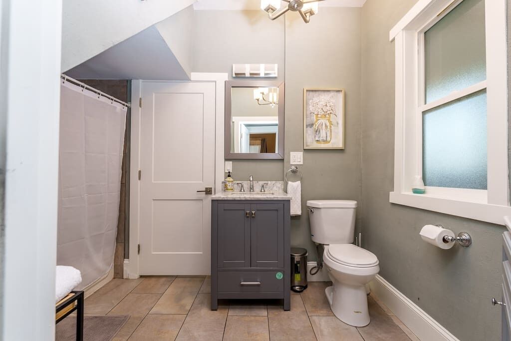 Une petite salle de bain comprenant une douche, des toilettes et un meuble-lavabo.