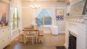 A cozy dining area with a wooden table, chairs, and a white fireplace. - Upgraded Home with 5BR/4Bath/4 FREE gated parking/EV Charger (Seattle)