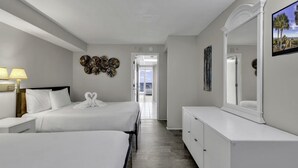 Habitación de hotel con dos camas, un aparador, un espejo grande y una pared decorada con platos.