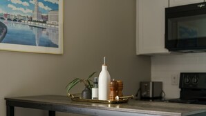 A kitchen with a metal table, a white bottle, a plant, and a tray with salt and pepper shakers.
