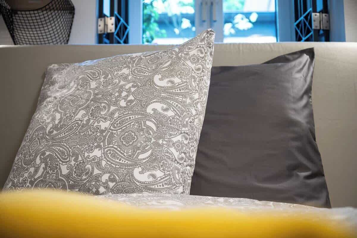 Ein Sofa mit einem gemusterten Kissen und einem schlichten Kissen.