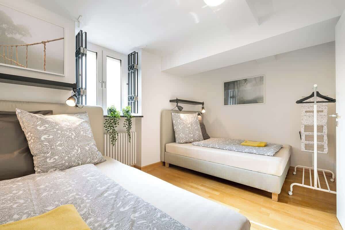 A modern bedroom with a bed, a sofa, and a radiator.