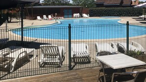 Area piscina con lettini e un pontile in legno.