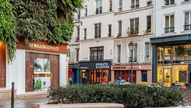 Un edificio con un negozio al piano terra chiamato "Le Magasin Asphalte".
