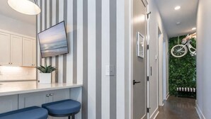 Eine Küche mit Fernseher, Streifenmuster an der Wand und einer Pflanze.