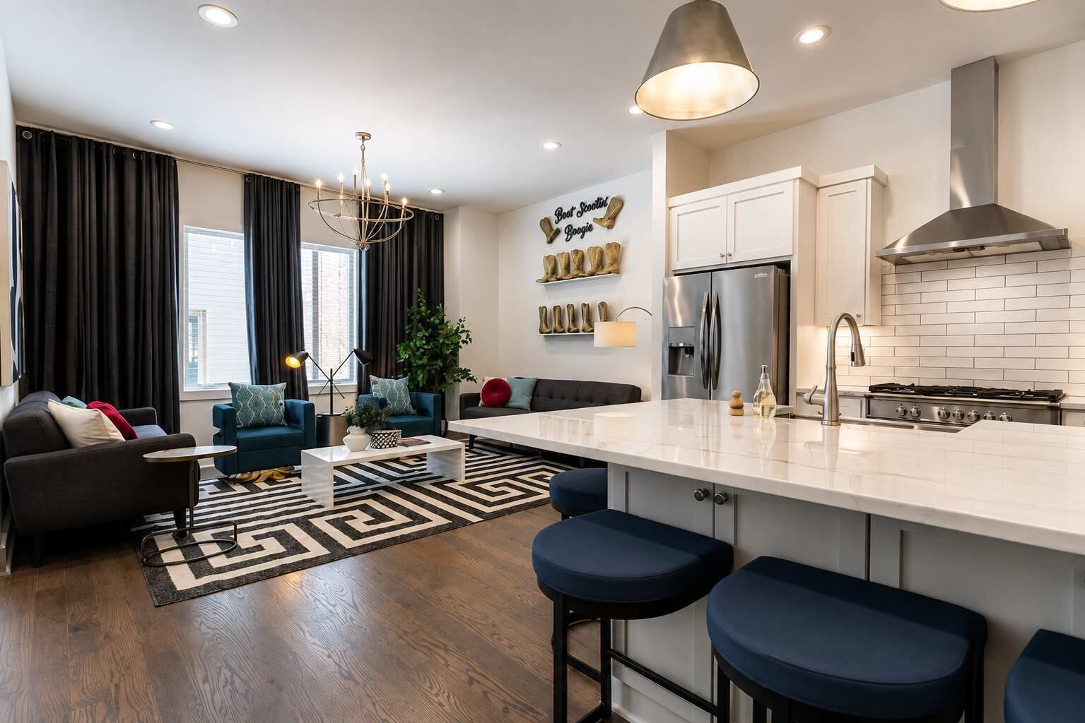 A modern kitchen with a central island, stainless steel appliances, and a bar stool seating area.
