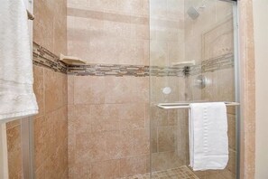 Een douche, handdoeken, zeep, toiletpapier