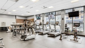 Un gimnasio con cintas de correr, elípticas y máquinas de pesas.