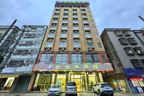 A multi-story hotel with a prominent entrance, air conditioning units, and a visible storefront with signage. - Renrenshun Hotel (Haifeng)