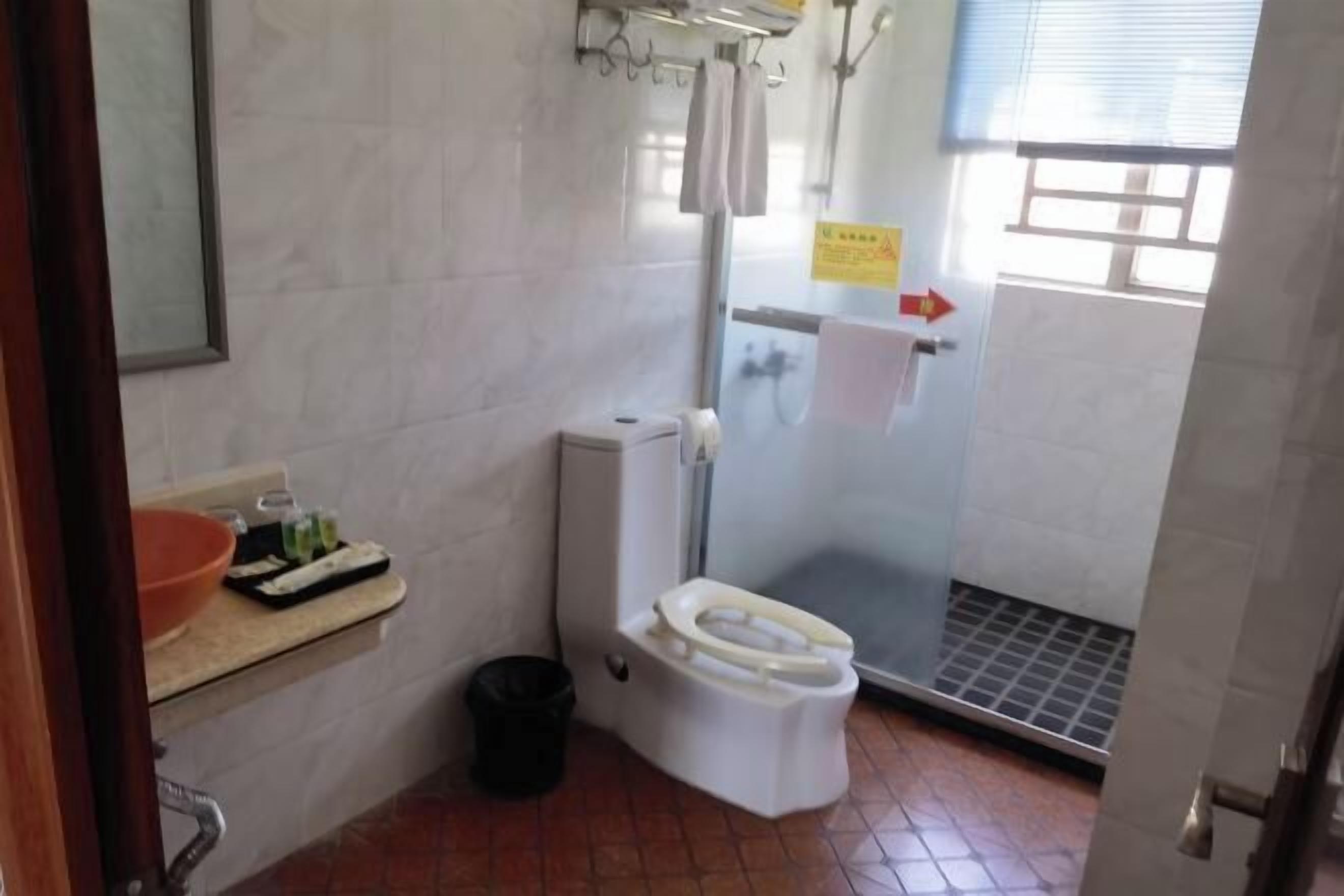 Um banheiro pequeno com vaso sanitário, pia e chuveiro.