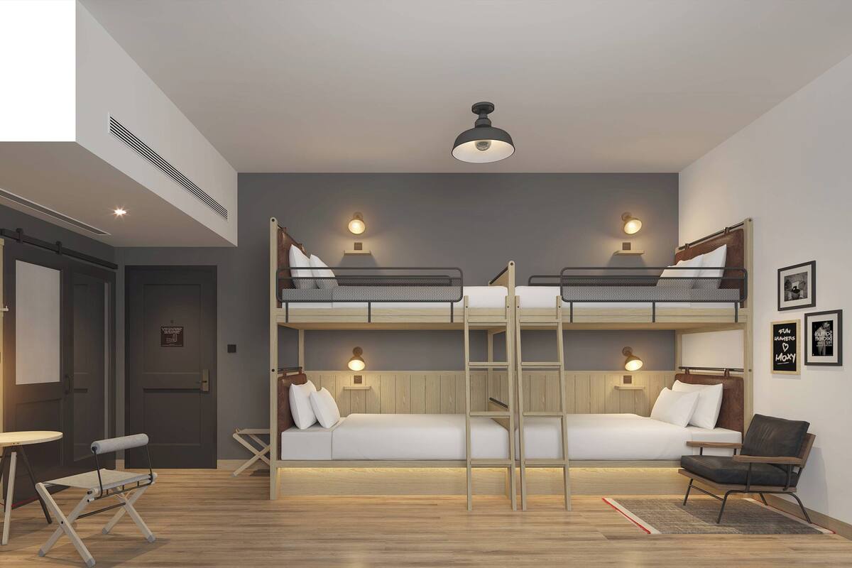 Quarto moderno com beliches, escrivaninha e cadeira.