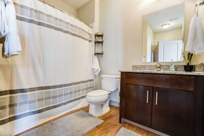 Bathtub, hair dryer, towels, shampoo