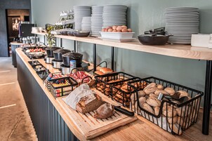 Een buffetopstelling met diverse etenswaren en keukengerei.