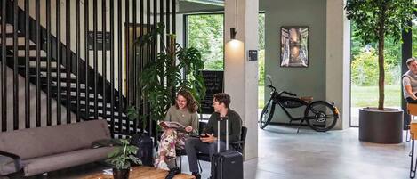 Ein modernes Interieur mit einer Treppe, einem Holztisch mit Pflanze und einem Fahrrad.