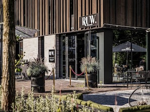 En restaurant ved navn Ruw med udendørs siddepladser og en træfacade.