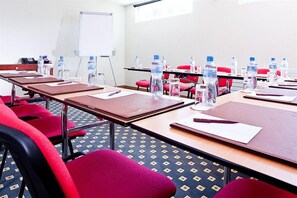 A conference room with tables, chairs, water bottles, and a whiteboard. - Mercure Fribourg Centre Remparts (Fribourg)