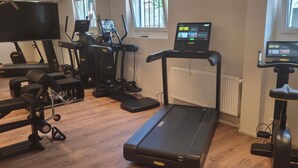 Un gimnasio con equipo de ejercicio, incluyendo cintas de correr, elípticas y máquinas de pesas.