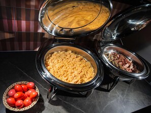 A slow cooker with a lid, a bowl of scrambled eggs, and a bowl of bacon. - Mercure Fribourg Centre Remparts (Fribourg)