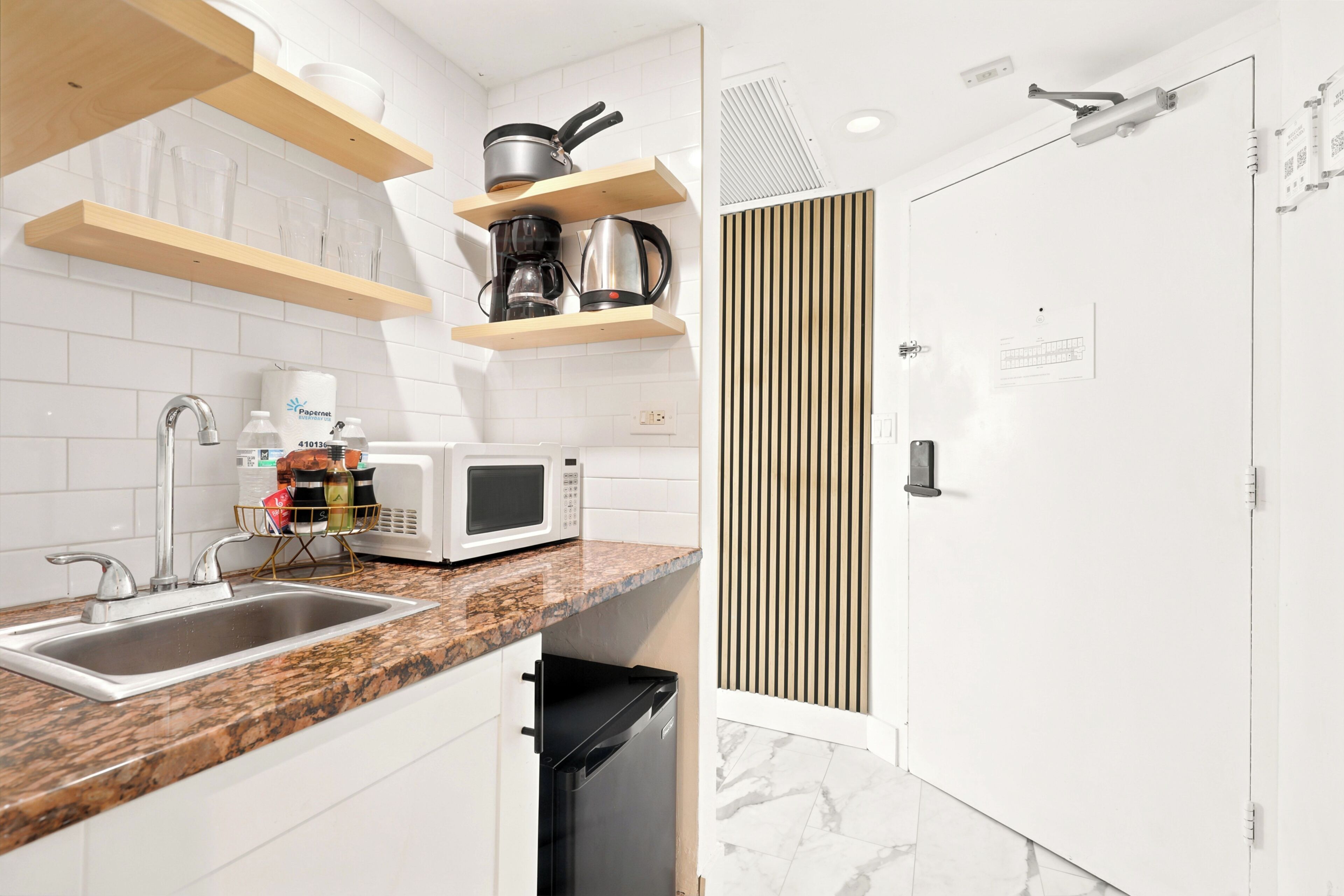 A modern kitchen with a granite countertop, stainless steel sink, and built-in appliances.