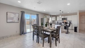 A modern kitchen with white cabinets, a microwave, and a sink.