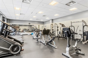 Academia com esteiras, elípticos e equipamentos de musculação.