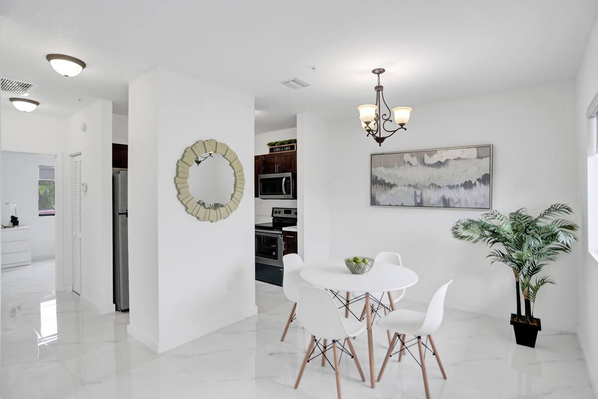 A modern kitchen with white cabinetry, a built-in oven, and a microwave.