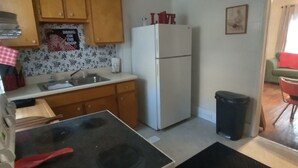 A compact kitchen with wooden cabinets, a white refrigerator, and a stove. - DUPLEX....and yes you get the whole house!!! (Northfork)