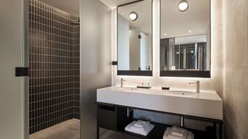 Un bagno moderno con un ampio specchio, due lavabi e un porta asciugamani.