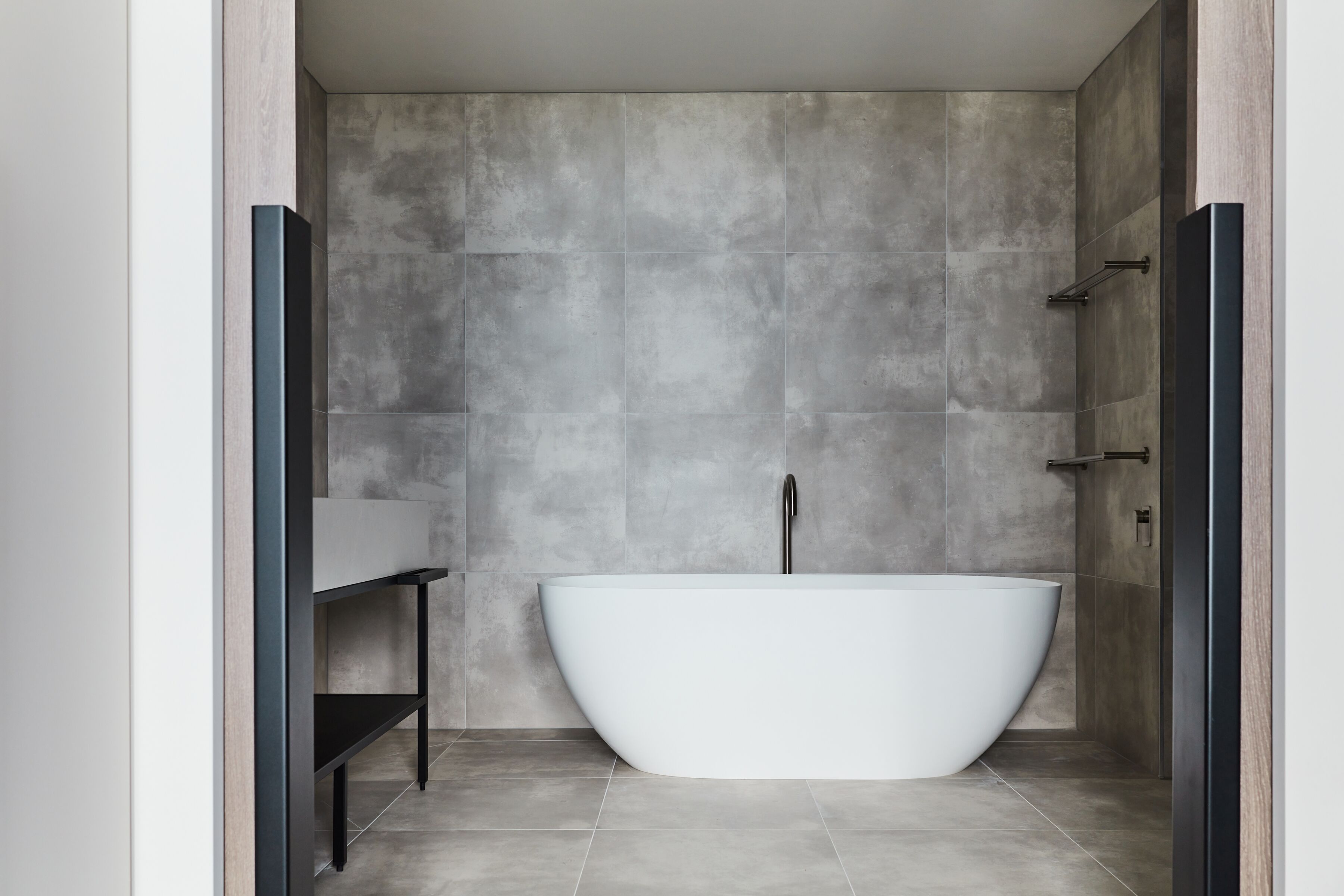 Un baño moderno con una bañera independiente, un tocador minimalista y una zona de ducha.