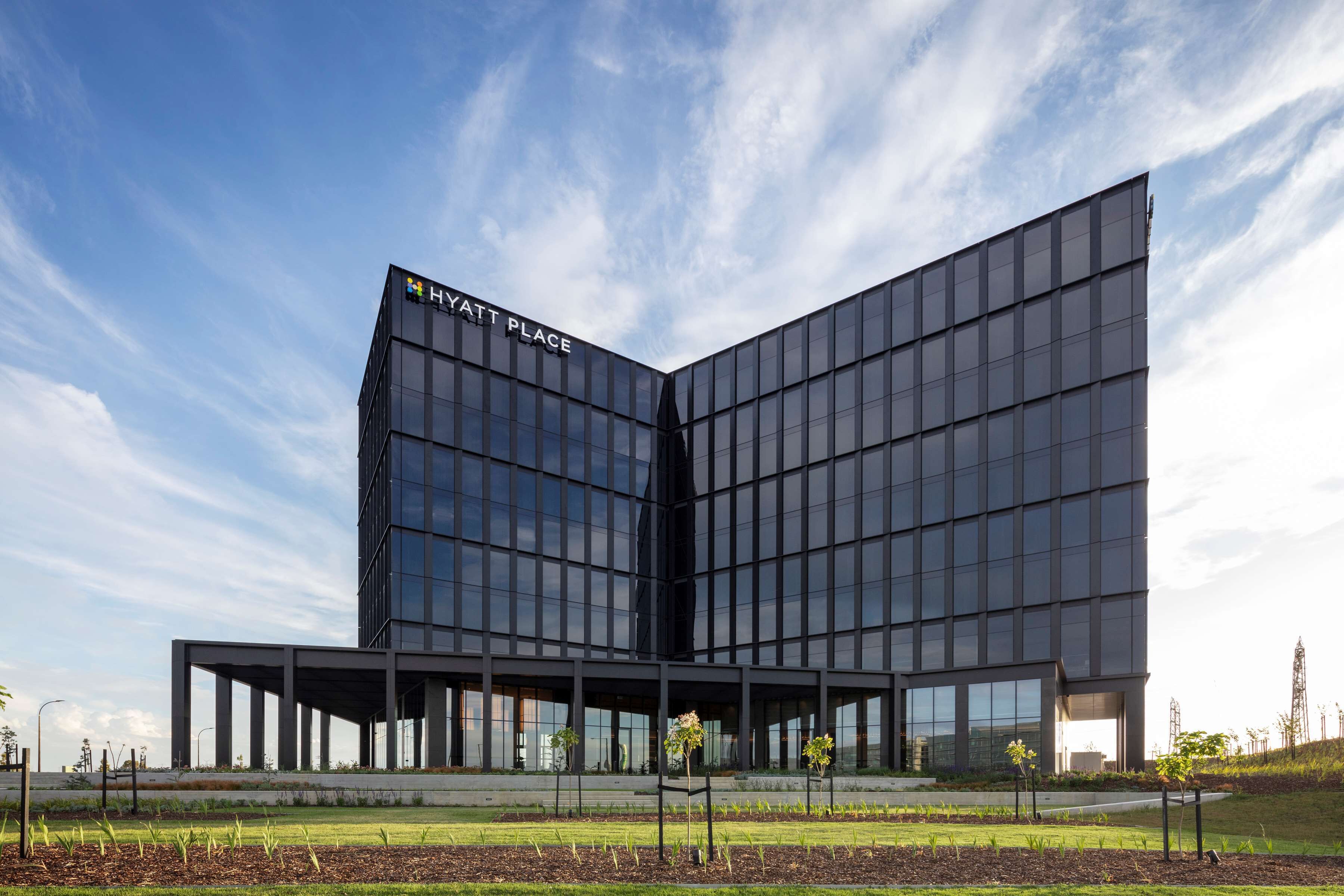 A modern building with a glass facade and a sign reading "HYATT PLACE".