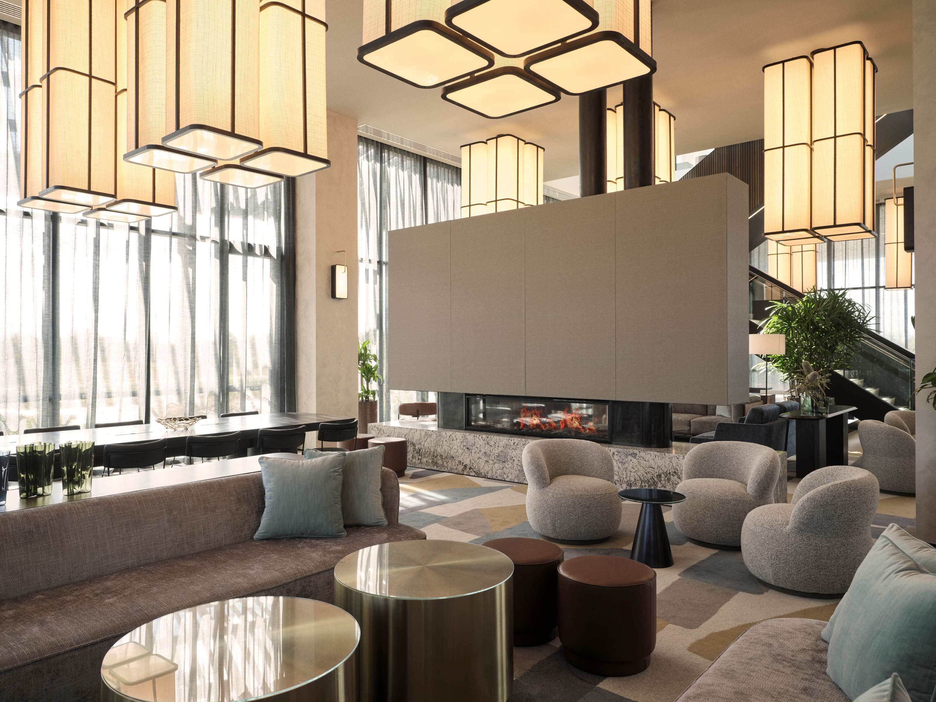 A modern lobby with a fireplace, comfortable seating, and stylish lighting fixtures.