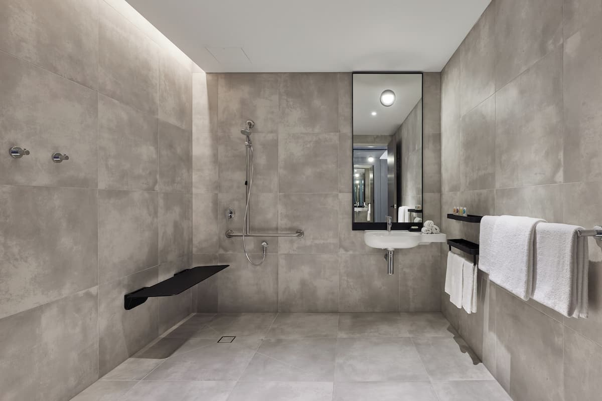 room, 1 king bed, mobility accessible | bathroom | shower, rainfall showerhead, designer toiletries, hair dryer