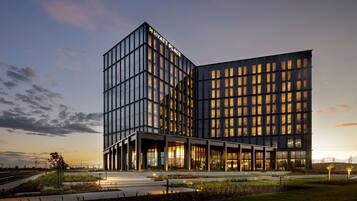A modern hotel with a glass facade, a prominent 'Hyatt Place' sign, and a landscaped entrance area.