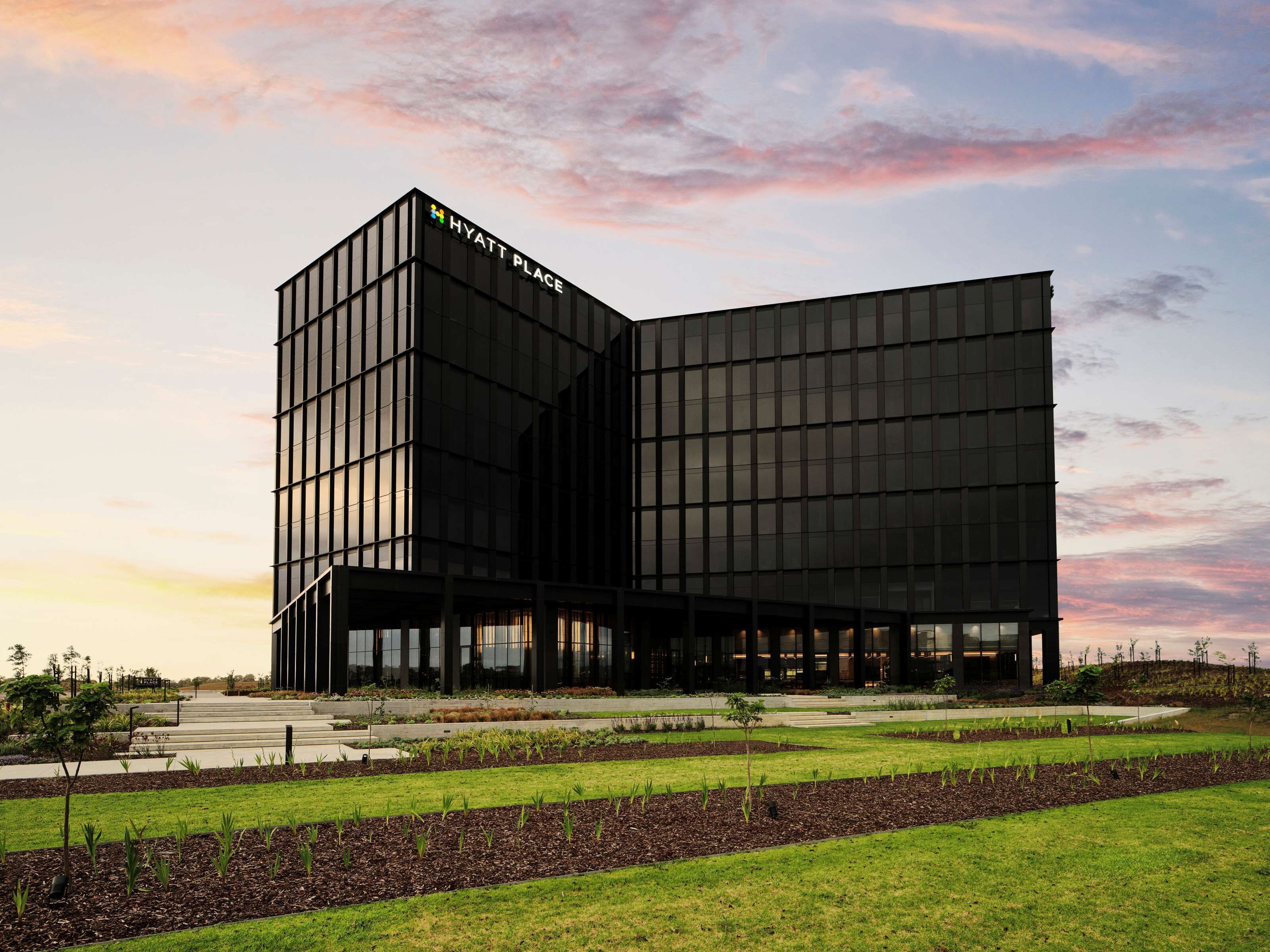A modern Hyatt Place hotel with a distinctive black facade and large windows.
