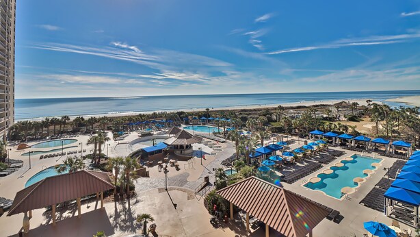 A resort with multiple swimming pools, beach views, and a large building to the left. - Labor Day Is Available Breathe Taking North Beach Resort Ocean Front Condo (North Myrtle Beach)