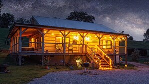 Een houten chalet met een veranda, een trap en een grindpad.