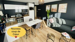 Un appartement moderne comprenant une cuisine, un coin repas et un salon.