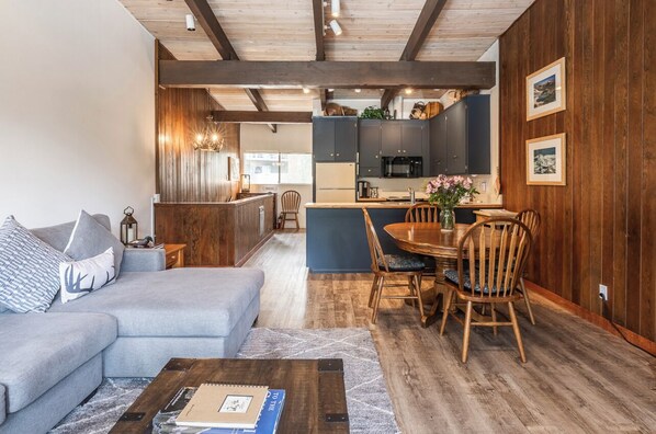 Un salon moderne comprenant un canapé, une table basse et un coin repas avec des chaises et une table.