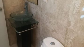 Chuveiro, toalhas de banho, sabonete, papel higiênico