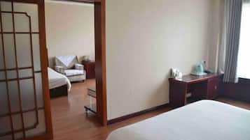Una habitación de hotel con una cama, un escritorio, una silla y un armario.