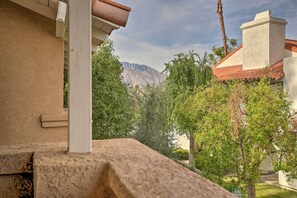 Blick vom Balkon auf eine Berglandschaft, mit einem Gebäude mit rotem Ziegeldach und Stuckfassade.