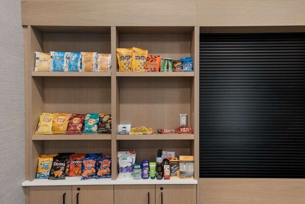 Une étagère où sont présentées différentes marques de produits d’épicerie salée, comme Lay’s et M&M’s.