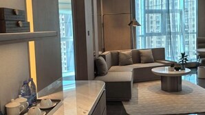 A modern living room with a sofa, a coffee table, and a tray with cups and a bottle. - Jinhao International Hotel (Huaining)