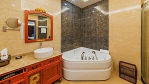 A modern bathroom with a large bathtub, a round mirror, and a vanity with a sink. - Jinhao International Hotel (Huaining)